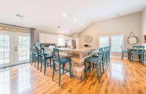 a kitchen and dining room with a bar with green chairs at Gone With The Wind - Duck, Gull's Flight, 325 Yds to Beach, Pool, Hot Tub, Pets OK, Quiet St, Flex Stays in Duck +43 photos