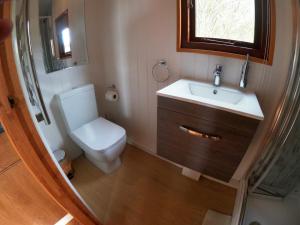 a small bathroom with a toilet and a sink at Herston Caravan & Camping in Swanage +39 photos