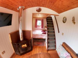 a room with a wood stove and a bedroom at Herston Caravan & Camping in Swanage