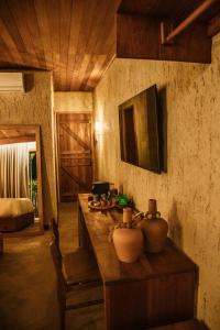 a room with a table with vases on it at Reserva Mazu in São Miguel dos Milagres
