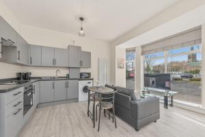 a kitchen and living room with a couch and a table at Ascot Grange Hotel & Apartments in Leeds