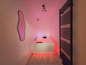 a bathroom with a white tub with pink lights at Suite Design Balnéo - Lit King size - Garage privé in Tournai