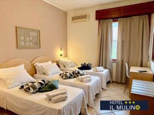 a hotel room with three beds with towels on them at Hotel IL MULINO - Colazione a Buffet e Parcheggio Privato in Casalgrande +9 photos