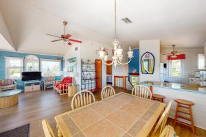 a dining room and living room with a table and chairs at Pelican Perch in Duck