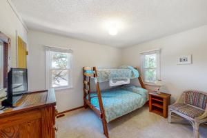 a bedroom with a bunk bed and a tv at Pelican Perch in Duck