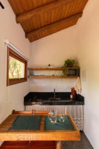 a kitchen with a wooden table and a sink at Casa Teiú in São Sebastião
