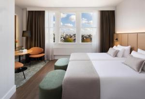 a hotel room with a large bed and a window at NH City Centre Amsterdam in Amsterdam