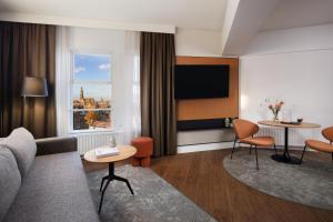 a living room with a couch and a table at NH City Centre Amsterdam in Amsterdam