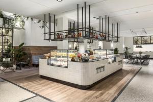 a restaurant with a counter with food on it at NH City Centre Amsterdam in Amsterdam +34 photos