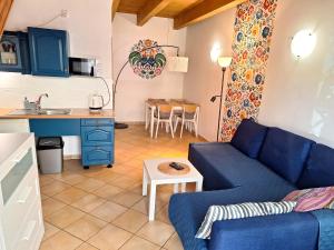 a living room with a blue couch and a kitchen at Pokoje Podzamcze in Stare Drawsko