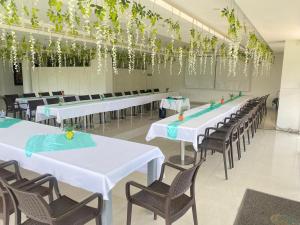 a banquet hall with white tables and chairs and plants at Hotel Palmeras De Luz in Moniquirá
