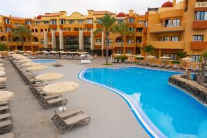 a resort with a swimming pool with chairs and umbrellas at Grand Muthu Golf Plaza Hotel & Spa in San Miguel de Abona +58 photos