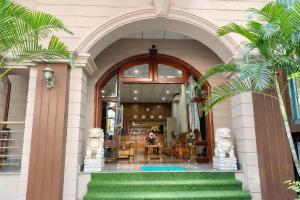 an entry to a building with an archway and palm trees at Lina Hotel Hồ Chí Minh in Dĩ An