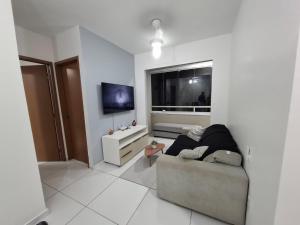 a living room with a couch and a television at AP a 3KM das PRAIAS, com SUÍTE in São Luís