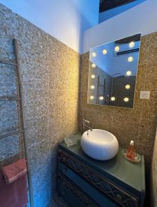 a bathroom with a sink and a mirror at La mandarine in Ramatuelle