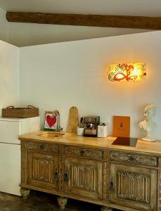 a kitchen with a wooden cabinet and a refrigerator at La mandarine in Ramatuelle