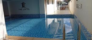 a swimming pool with blue tiles in a building at Little Haven Stays-Near UN & Two Rivers in Ruaka