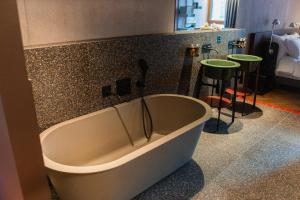 eine Badewanne in einem Badezimmer mit einer Ablage in der Unterkunft Hôtel Borsari, A Member of Design Hotels in Martigny-Ville + 51 Fotos