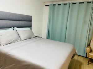 a bedroom with a white bed with blue curtains at Lagoon Staycation in Walvis Bay