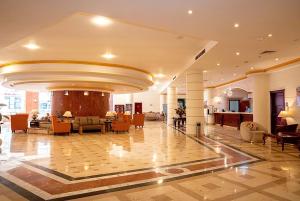 a lobby of a hotel with tables and chairs at Dexon Roma Down Town Hotel in Hurghada +124 photos