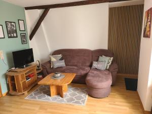 a living room with a brown couch and a coffee table at Weingut Matthias Dauns in Reil