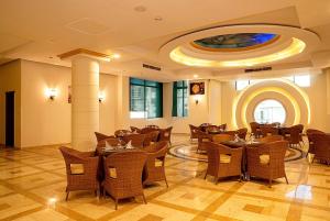 a restaurant with tables and chairs in a room at Dexon Roma Down Town Hotel in Hurghada