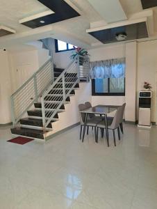 a dining room with a table and a staircase at Rweydz Guest Inn Dorm in Tagbilaran City