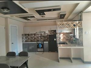 a kitchen with a table and a counter top at Rweydz Guest Inn Dorm in Tagbilaran City +4 photos
