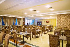 a restaurant with tables and chairs in a room at Dexon Roma Down Town Hotel in Hurghada