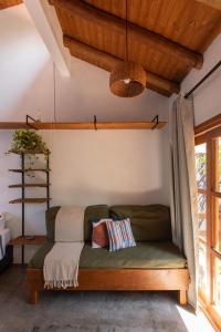 a bedroom with a green couch in a room at Casa Teiú in São Sebastião