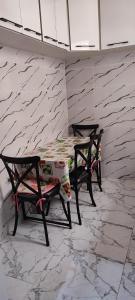 a table and two chairs sitting next to a stone wall at Luxury house in Ariana