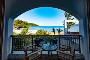 a balcony with a table and chairs and a view of the ocean at Kanali seaside apartment Poros 2 in Poros