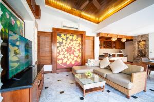 a living room with a couch and a tv at Prima Villas Chalong Phuket in Chalong
