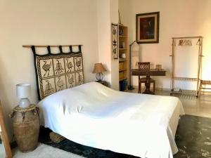 a bedroom with a large white bed and a table at Camera con bagno privato e terrazzo a 10 minuti dalla Stazione Centrale - Oasis Bologna Centro in Bologna