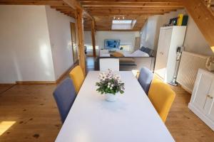 a dining room with a white table and yellow chairs at Loft Chaleureux - Le Chalet Montois in Mons