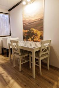 a table and chairs in a room with a painting at Motel Remo in Lovrin
