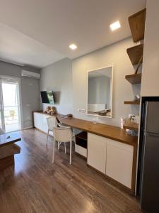a kitchen with a desk and a mirror on the wall at Beachfront Apartment Saranda in Sarandë