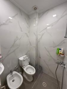 a white bathroom with a toilet and a sink at Beachfront Apartment Saranda in Sarandë +19 photos