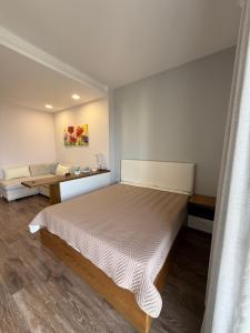 a bedroom with a large bed and a couch at Beachfront Apartment Saranda in Sarandë