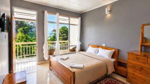 a bedroom with a bed and a large window at Shikher Guest House in Kalimpong
