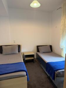 a room with two beds and a table in it at Dragoti in Leptokarya