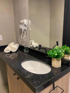 a bathroom counter with a sink and a mirror at One Studios Indaiatuba in Indaiatuba +72 photos