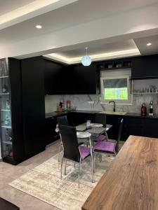 a kitchen with a table and purple chairs at Dragoti in Leptokarya
