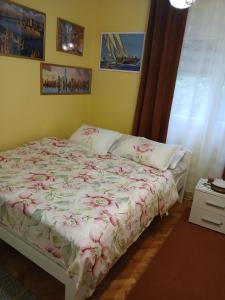 a bedroom with a bed with a floral bedspread at Apartments Vučinović in Tivat
