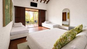 a large bedroom with two beds and a balcony at Hotel Acantilado de La Tierra by On vacation in San Andrés