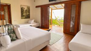 a living room with two white couches and a balcony at Hotel Acantilado de La Tierra by On vacation in San Andrés