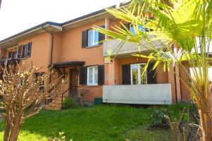 a house with a palm tree in front of it at Casa Vacanza Neris in Clusane sul Lago