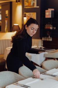 a woman sitting at a table in a restaurant at HasHotel in Hasselt
