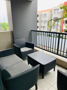 a balcony with chairs and a table on a balcony at The Bridge at Montego in Fourways