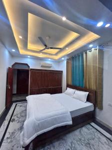 a bedroom with a large bed with a ceiling at The great Garuda hotel in Rishīkesh +7 photos